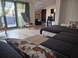 a living room with two beds and a couch at Apartman Gradina in Doboj