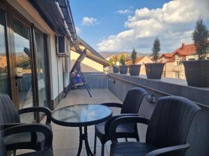 a patio with chairs and a table on a balcony at Apartman Gradina in Doboj