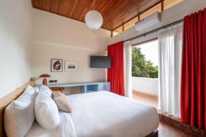 a bedroom with a bed with red curtains and a window at Céline & Lolo in Nairobi +36 photos