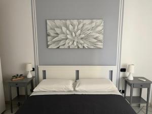 a bedroom with a bed with a picture on the wall at FUORI PORTA NUOVA in Sarzana +3 photos
