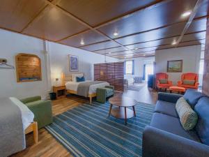a hotel room with a bed and a couch and chairs at Wilder Bunkhouse in De Smet