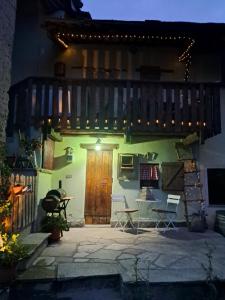 a house with a wooden door and a patio at night at Rifugio Felice in Bagnolo Piemonte