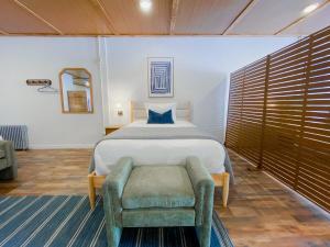 a bedroom with a bed and a chair in it at Wilder Bunkhouse in De Smet