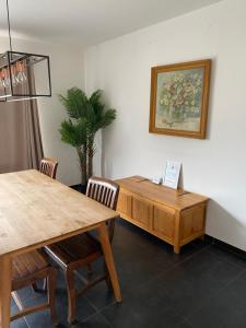 a dining room with a table and chairs and a painting at Woning met 4 slaapkamers in Zelzate
