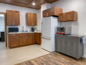 a kitchen with a white refrigerator and wooden cabinets at Wilder Bunkhouse in De Smet +47 photos