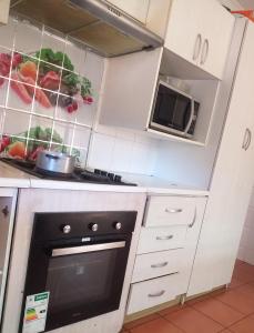 a kitchen with white cabinets and a microwave at Mestil Guesthouse in Hoheizen