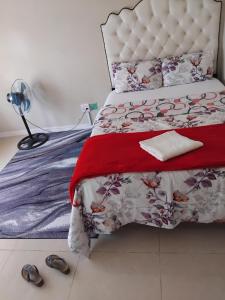 a bedroom with a bed and a lamp and shoes at Mestil Guesthouse in Hoheizen