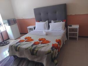a bedroom with a bed with a bedspread with flowers on it at Mestil Guesthouse in Hoheizen