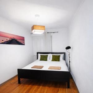 a bedroom with a bed with a black and white bedspread at Cascais Little Garden Rooms Old Town in Cascais +6 photos