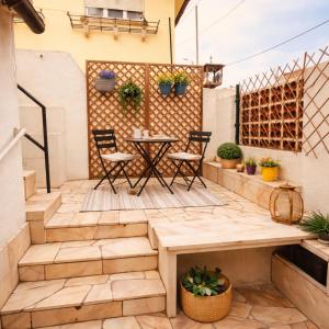 a patio with a table and chairs and a fence at Cascais Little Garden Rooms Old Town in Cascais