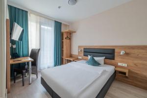 a bedroom with a bed and a desk with a computer at Hotel Gute Hoffnung Pforzheim in Pforzheim +13 photos