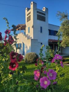 a building with flowers in front of it at Beachfront cottage house in olive grove in Arkitsa