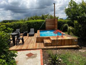 a wooden deck with a pool and a table and chairs at Cabaña alpina Júpiter in Armenia