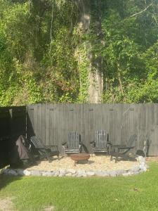 a group of chairs sitting in front of a fence at Tiny Home in Town-Hot Tub - Privacy Fence - Fire Pit - Kids Play Area & 15 minutes to the Bogue Chitto State Park in Franklinton +16 photos