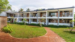 an exterior view of a white building with a yard at Surfing Elephant in Matara