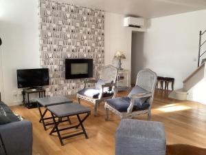 a living room with two chairs and a television at Le jardin des chanceliers in Beaune +24 photos