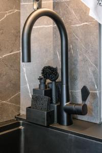 a kitchen sink with a black kitchen faucet at Kitz Alpine Apartments - City Center in Kitzbühel