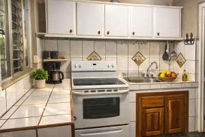 a white kitchen with a stove and a sink at Casa Bandera 54 in Guayabal