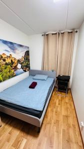 a bed in a room with a painting on the wall at Ulven Paradise in Oslo