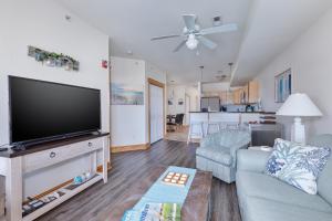 a living room with a large flat screen tv at C103A - Sweet Sound Memories in Nags Head +16 photos