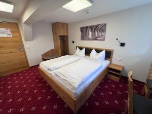 a bedroom with a large bed with white sheets at Doppelzimmer 11 in Heidenheim