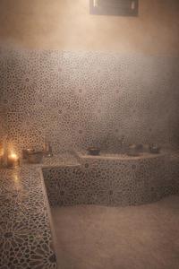 a bathroom with a sink and a wall at Riad Aïcha Addi Pool & Hammam in Essaouira