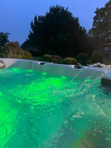 a pool with green lights in the water at The TreeHouse Hideaway in Shrewsbury +34 photos