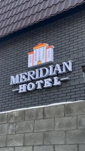 a sign for a marriott hotel on a brick wall at Meridian Hotel in Almaty