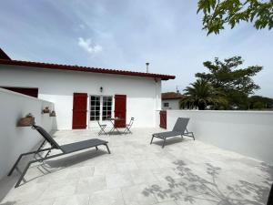 eine Terrasse mit zwei Stühlen und ein weißes Gebäude in der Unterkunft Pitabitxi in Bardos