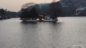 a house on a island in the middle of a river at Charming Lake View Camp in Bhīm Tāl