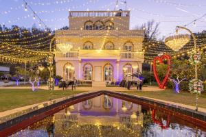 a house with christmas lights and a pond in front of it at Vila Dy Bukurite Durres in Draç +62 photos