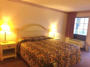 a hotel room with a bed and two lamps at Budget Inn New Cumberland-Harrisburg-Hershey-York in New Cumberland