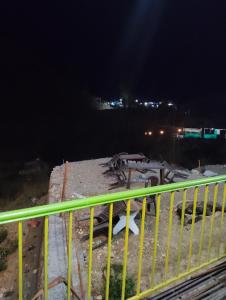 a yellow railing on a bridge at night at Nanda devi hotel in Mussoorie