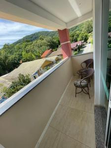 a balcony with chairs and a view of a mountain at Pousada Recanto Armação in Penha