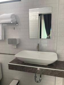 a white bathroom with a sink and a mirror at Adira Residence in Ao Nang Beach