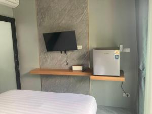 a bedroom with a bed and a television on a shelf at Adira Residence in Ao Nang Beach