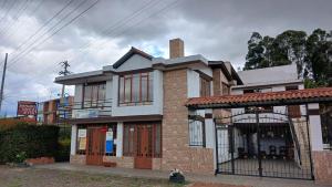 a house with a gate in front of it at Cabaña el Rincon Del Lago in Paipa