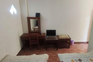 ein Zimmer mit einem Schreibtisch, auf dem ein Laptop und ein Spiegel stehen. in der Unterkunft Hotel Bima in Klaten