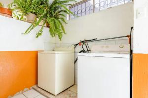 a laundry room with a washing machine and a plant at SUITE AMOBLADA TODO INCLUIDO in Quito