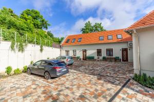 two cars parked in a parking lot in front of a house at Monbuhim Four in Veszprém