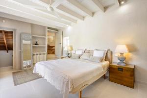 a white bedroom with a large bed and a table at Ca Na Ramona - Finca with Pool Santa Eularia in Santa Eularia des Riu +32 photos