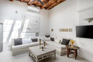 a living room with a white couch and a tv at Ca Na Ramona - Finca with Pool Santa Eularia in Santa Eularia des Riu