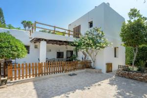 a white house with a wooden fence and trees at Ca Na Ramona - Finca with Pool Santa Eularia in Santa Eularia des Riu