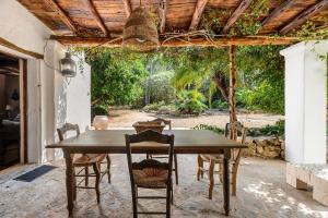 a wooden table and chairs on a patio at Ca Na Ramona - Finca with Pool Santa Eularia in Santa Eularia des Riu