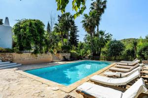 a swimming pool with lounge chairs and a villa at Ca Na Ramona - Finca with Pool Santa Eularia in Santa Eularia des Riu