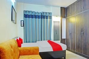 a bedroom with a bed and a couch at Super Hotel O New View in Bankipur