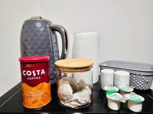 a counter with a container of coffee and a jar of food at Enjoy the comfort at private room en-suite with free Parking - near Luton airport in Luton