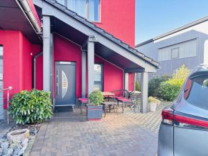 a red building with a table and chairs at Hotel 108 in Glinde bei Hamburg in Hamburg