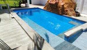 a large swimming pool with a rock in the background at Casa Bandera 54 in Guayabal