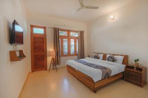 a bedroom with a bed and a flat screen tv at Bir Downtown in Bīr
